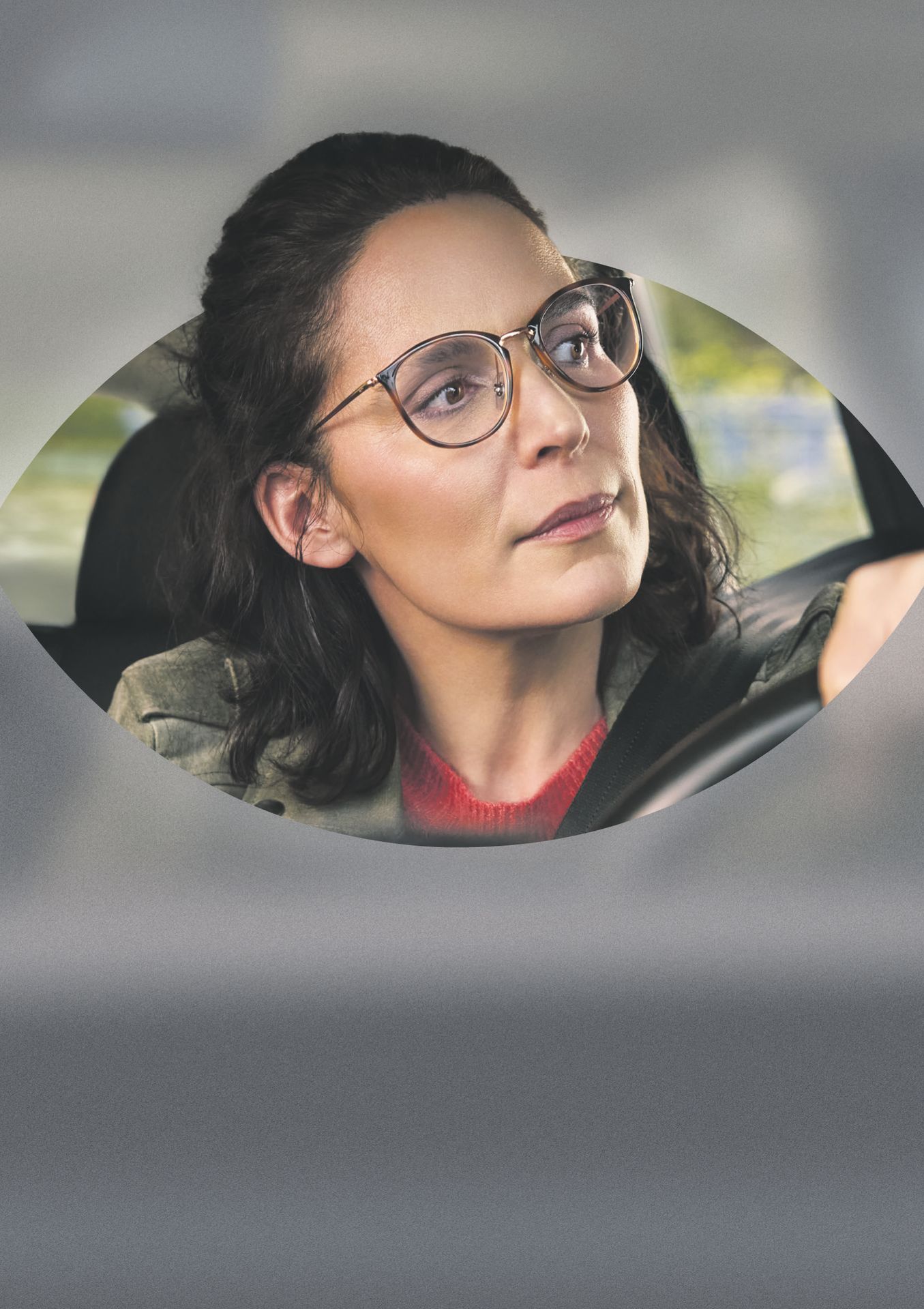 Frau mit Gleitsichtbrille am Steuer eines Autos bei Abendlicht