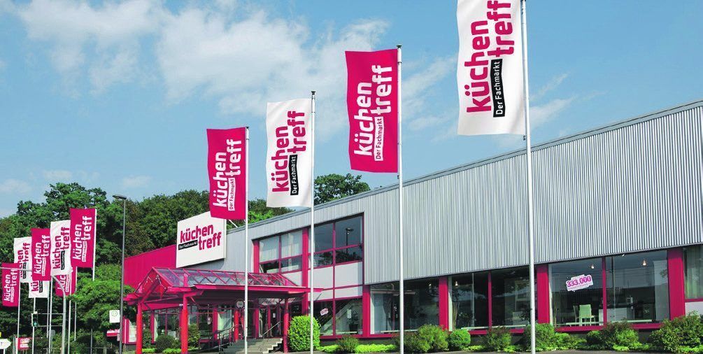 Küchentreff Filiale mit Werbefahnen vor blauem Himmel