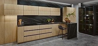 Holzküche in Eiche mit schwarzer Marmorrückwand und Barhocker