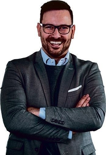 Lachender Verkaufsberater mit Brille im grauen Sakko