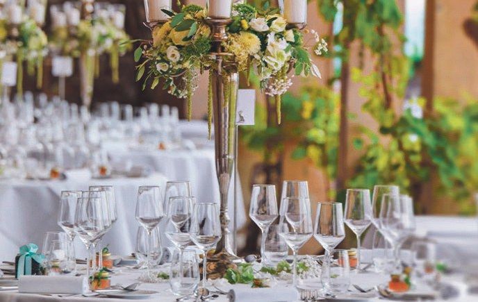 Festlich gedeckte Hochzeitstafel mit Weingläsern, Kerzenleuchter und weißem Blumenschmuck