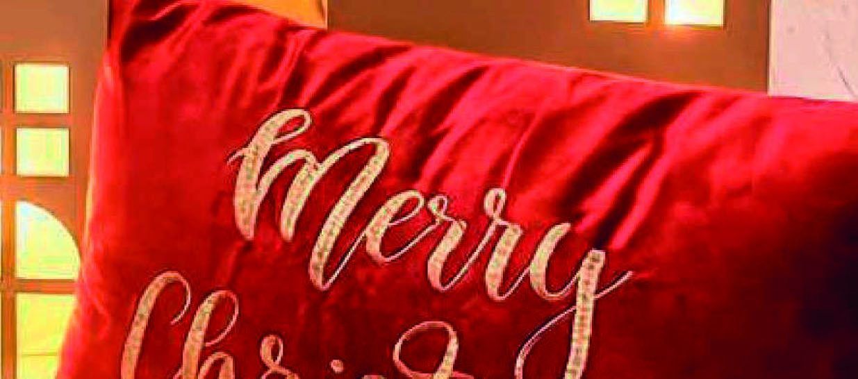 Rotes Samtkissen mit goldenem Merry-Christmas-Schriftzug